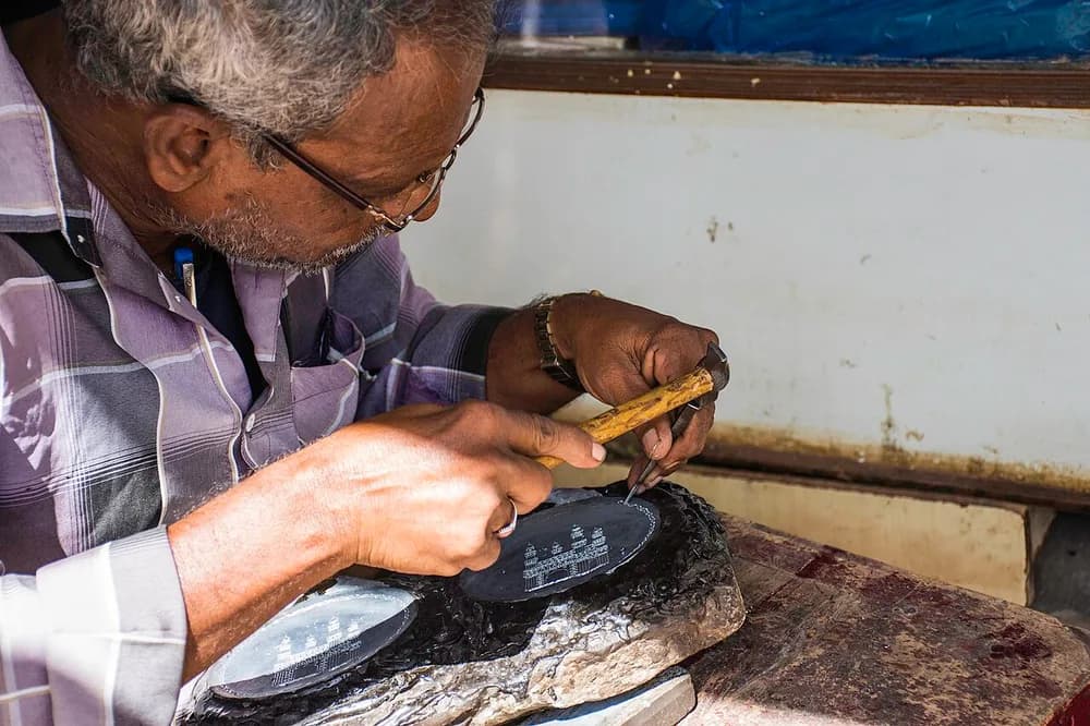 Artisan making decorative Bidriware metalwork