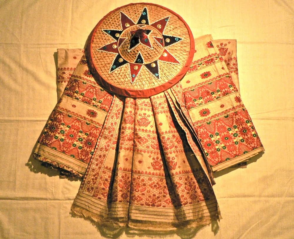 Assamese Muga textile displayed with a traditional japi